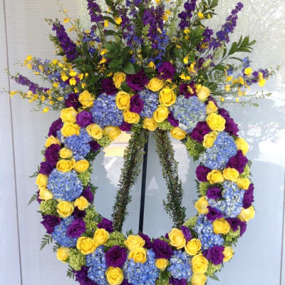 Large floral wreath with yellow and purple roses and blue hydrangeas