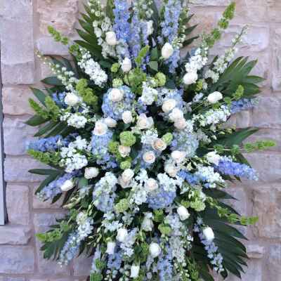 Large standing floral spray with white roses and blue flowers
