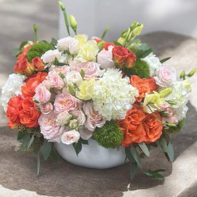 Mixed bouquet of roses and white hydrangeas in a white bowl vase