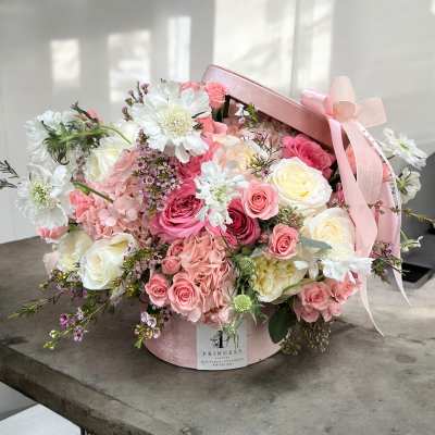 Pink and white rose bouquet in a round pink hat box with ribbon
