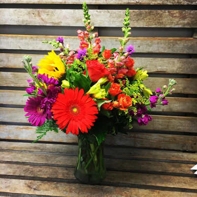 Colorful mixed bouquet in a dark glass vase