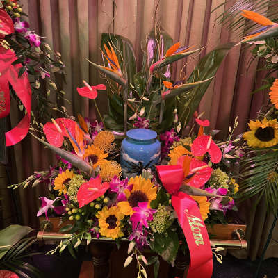 Large tropical floral arrangement with sunflowers, orchids, and an urn centerpiece