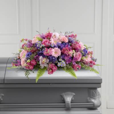 Pink and purple floral spray on a gray casket