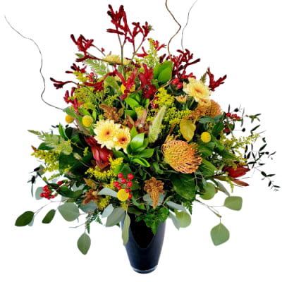 Mixed bouquet with red and yellow flowers in a dark vase