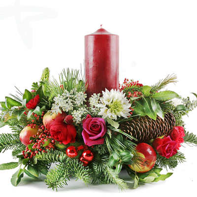 Holiday centerpiece with red candle, roses, and evergreen accents