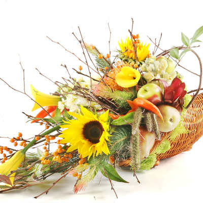 Autumn floral arrangement in a woven cornucopia basket with sunflowers and calla lilies