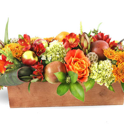 Autumn floral arrangement in a rectangular wooden box with orange and red blooms