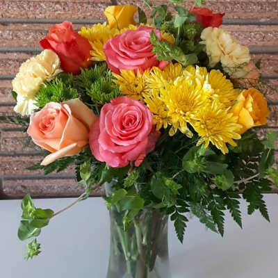 Mixed bouquet of roses and yellow chrysanthemums in a glass vase