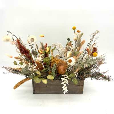 Dried floral arrangement in a wooden box with white and yellow blooms