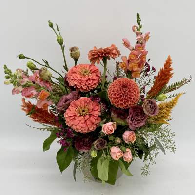 Mixed bouquet of coral, pink, and orange flowers in a vase