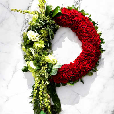 Heart-shaped floral wreath with red roses and green-white flowers