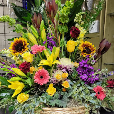 Large mixed flower basket with lilies, roses, gerberas, and sunflowers