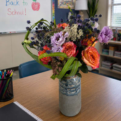 Bouquet of orange and lavender flowers in a blue ceramic vase