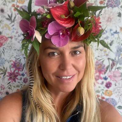 Woman wearing a floral crown with orchids and anthuriums