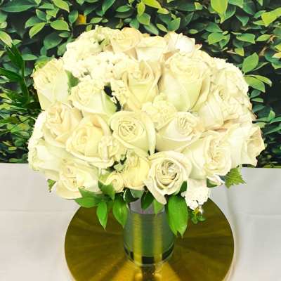 Cream rose bouquet in a metallic vase on a gold base