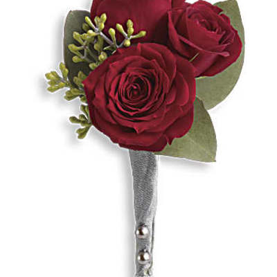 Three red roses arranged as a boutonniere with green accents and a silver-wrapped stem
