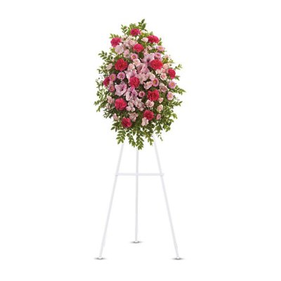 Pink and red floral standing spray on a white easel