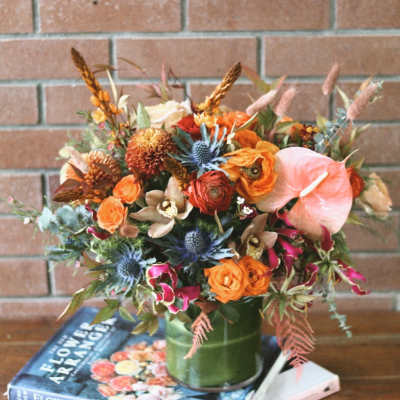 Orange and pink mixed bouquet in a green vase