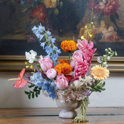 Colorful mixed flower arrangement in a striped ceramic vase