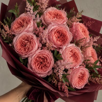 Bouquet of pink roses wrapped in burgundy paper