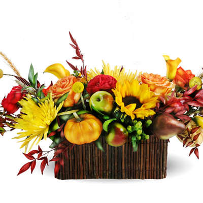 Autumn floral arrangement with sunflowers, roses, and fruit in a rectangular basket