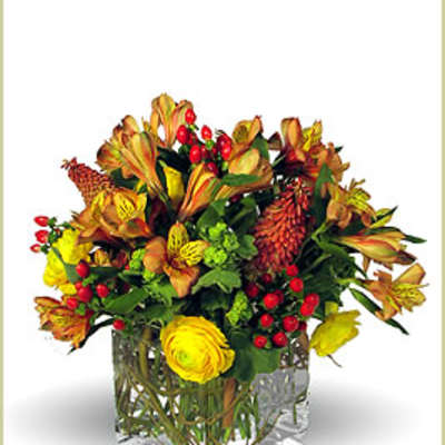 Autumn bouquet in a clear square vase with yellow and orange flowers