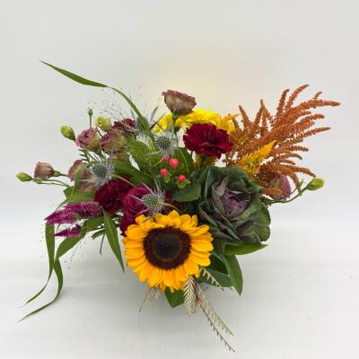 Mixed bouquet with a sunflower, burgundy blooms, and orange accents