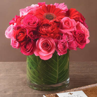 Pink and red roses with gerbera daisies in a glass vase