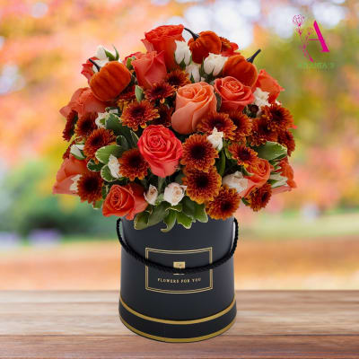 Orange roses and mums arranged in a black hatbox