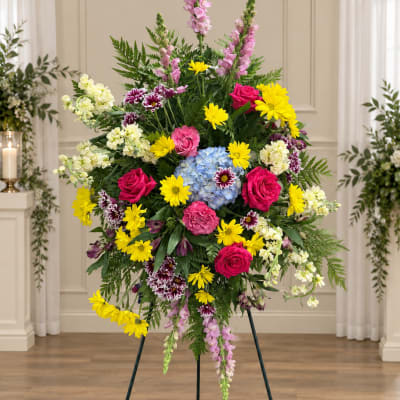 Tall standing floral spray with pink, yellow, blue, and white flowers