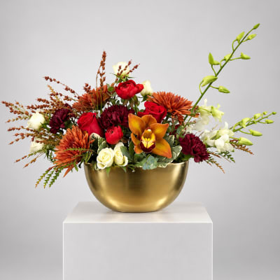 Mixed bouquet in a gold bowl with red, white, and orange flowers