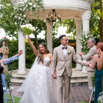 Bride and groom at a wedding ceremony with a white tulip bouquet