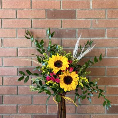 Sunflower and pink rose arrangement in a tall vase