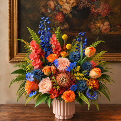 Colorful mixed flower arrangement in a pink ribbed vase