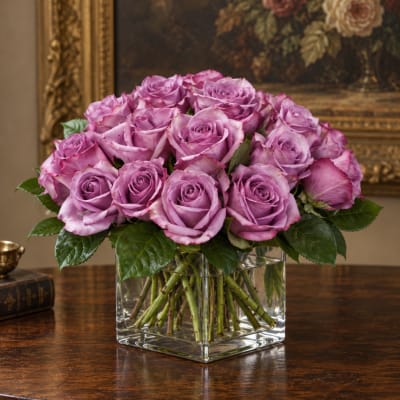 Lavender roses arranged in a clear square glass vase