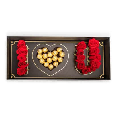 Heart-shaped chocolate box with red roses arranged around it