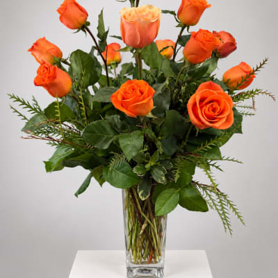 Orange roses arranged in a clear glass vase