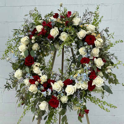 Large floral wreath of red and white roses on a stand