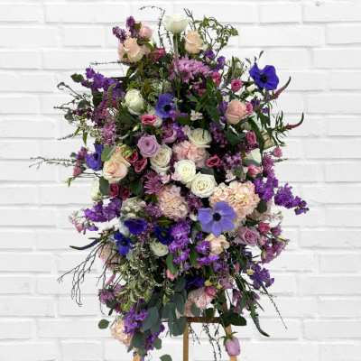 Tall standing floral spray with purple, pink, and white blooms