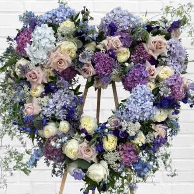 Heart-shaped floral wreath with pastel roses and hydrangeas