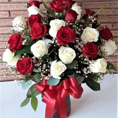 Bouquet of red and white roses with a red ribbon in a vase
