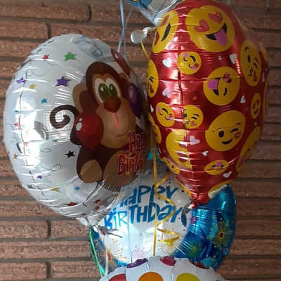 Cluster of birthday balloons with colorful polka dots and emoji designs