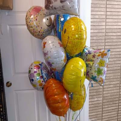 Cluster of colorful helium balloons with birthday and get-well messages