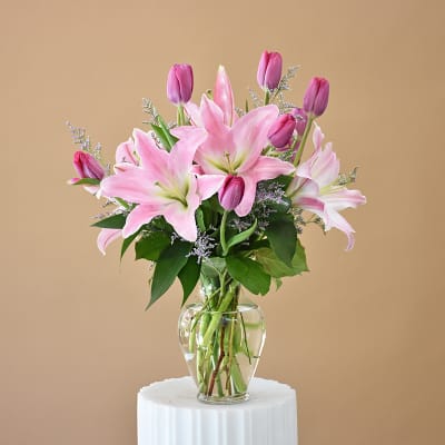 Pink lilies and tulips in a clear glass vase