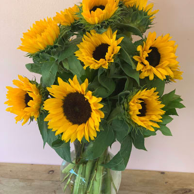 Bouquet of yellow sunflowers in a clear glass vase