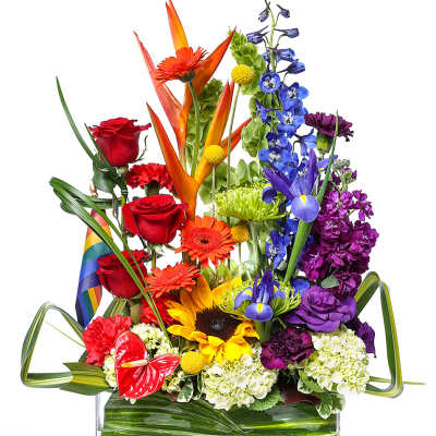 Colorful mixed bouquet in a clear rectangular vase with rainbow ribbon
