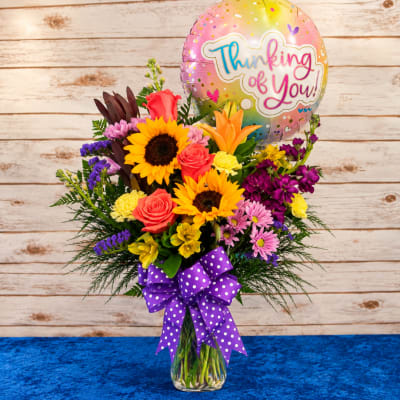 Mixed bouquet in a glass vase with a Thinking of You balloon