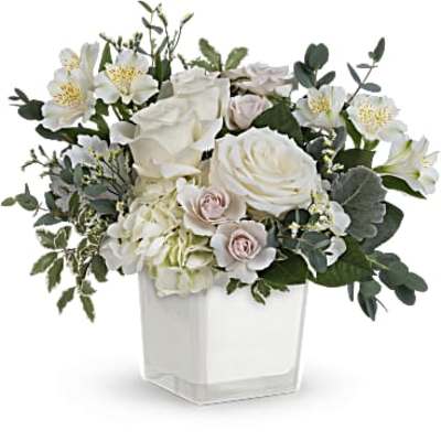 White floral arrangement in a clear square vase
