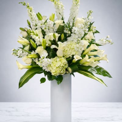 White floral arrangement in a tall glass vase