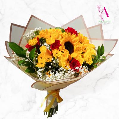 Bouquet of yellow sunflowers and red roses wrapped in translucent paper